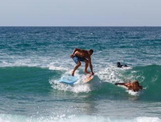 Un surfeur qui saute d'une planche à une autre à Lacanau