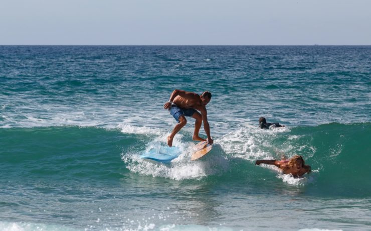 Un surfeur qui saute d'une planche à une autre à Lacanau