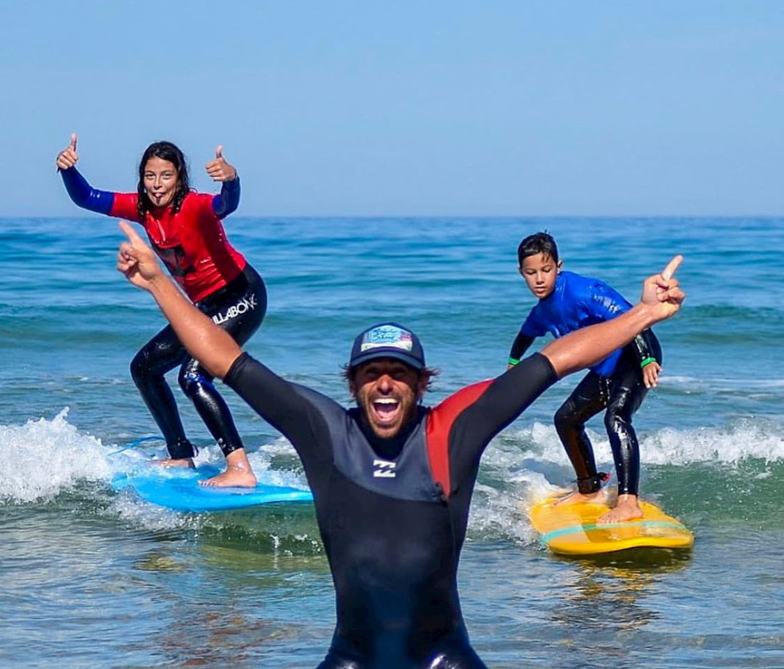 Adrien et ses stagiaires debout sur leurs planches de surf