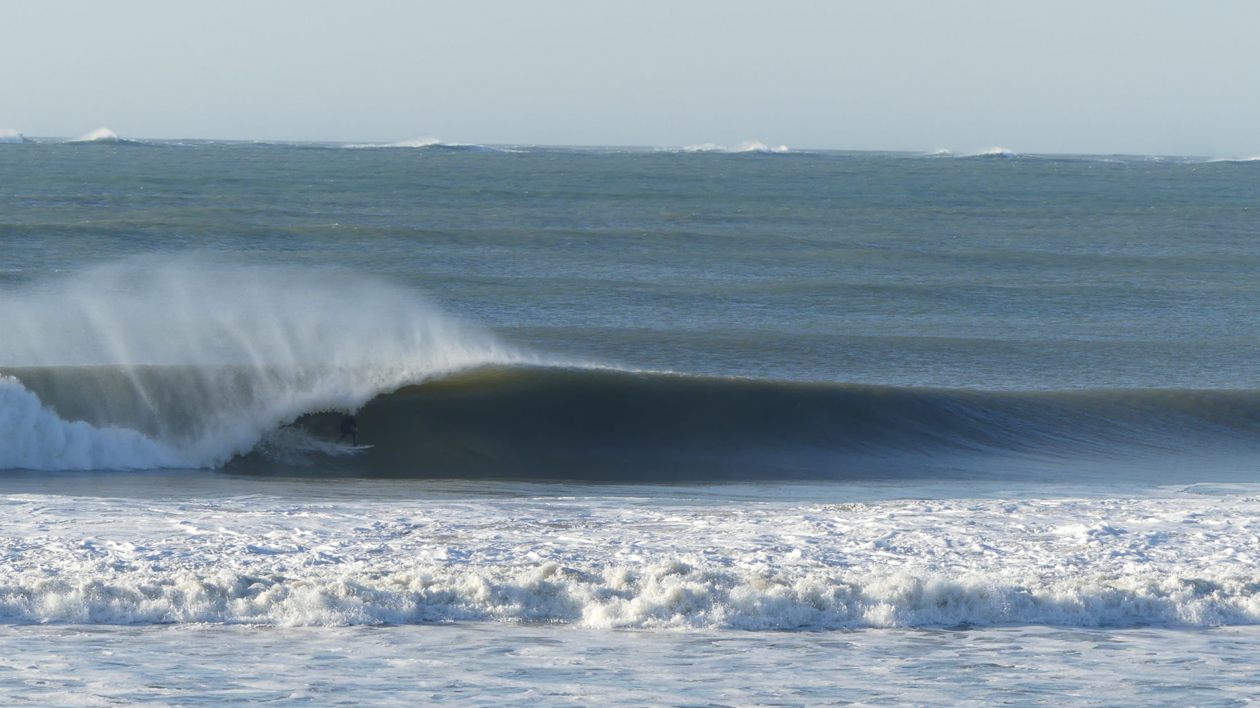 un surfeur entrant dans un tube su une belle vague en gironde