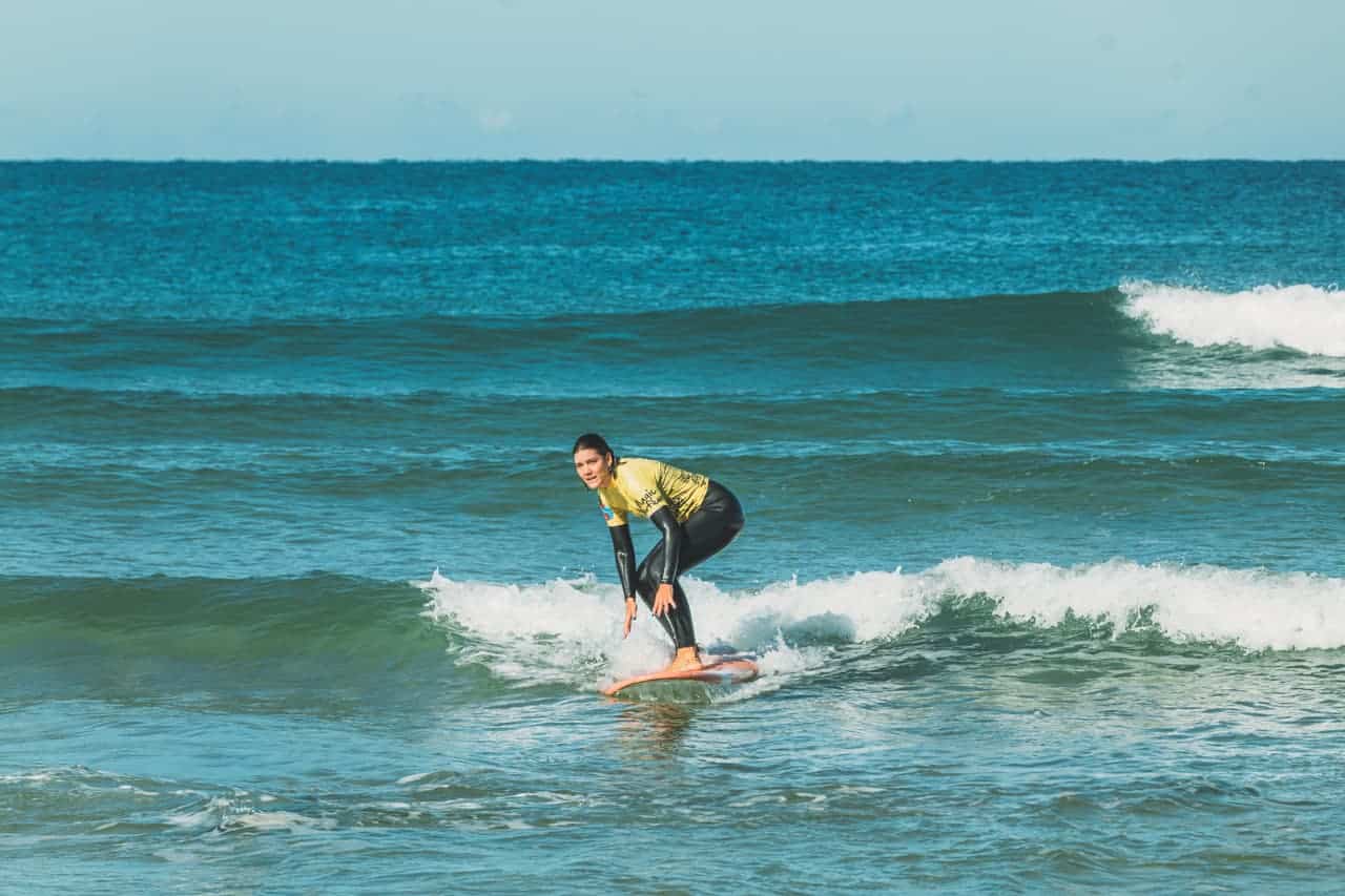 decouverte-2 Une surfeuse debout sur sa planche durant un stage découverte à Lacanau