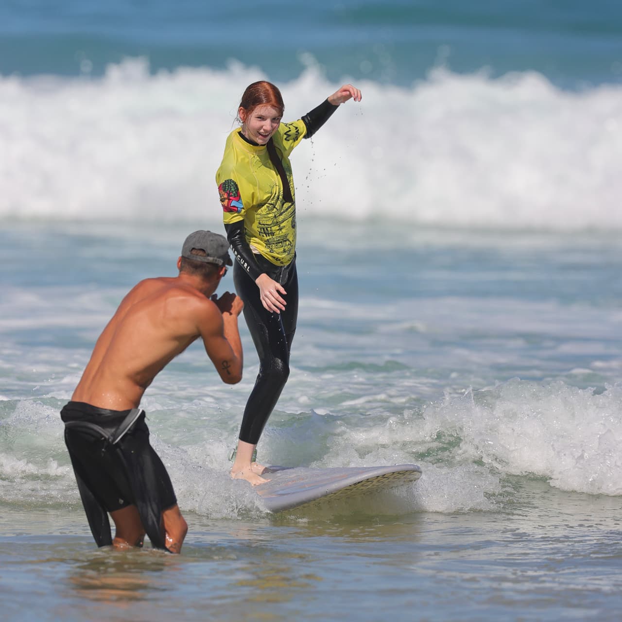 Un moniteur de surf donne des conseils à son élève directement dans l'eau